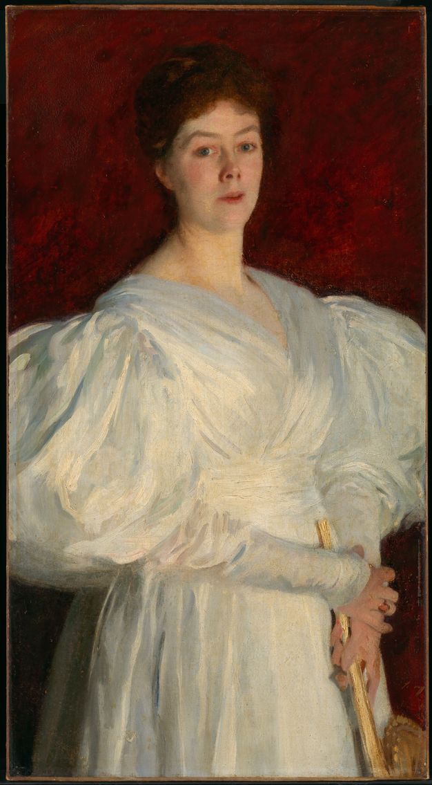 Painting. Shown from the hips up, a pale-skinned woman wearing a white gown with hugely puffed sleeves stands in front of a garnet-red background. Her shoulders angle to our right but she turns to look at us, her peaked eyebrows raised, and her lips parted. The sleeves extend off both sides of the canvas.